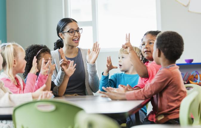 Image of an educator speaking with children