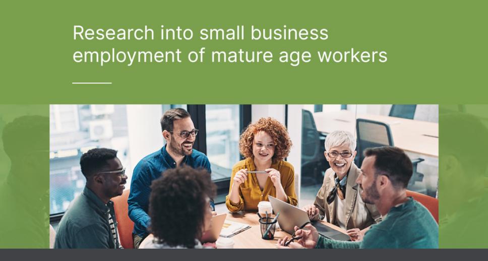 Six office workers enjoying a discussion while seated around a circular table. The caption positioned to the left reads: "Research into small business employment of mature age workers".