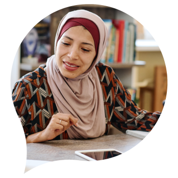 Woman wearing headscarf sitting in front of computer tablet